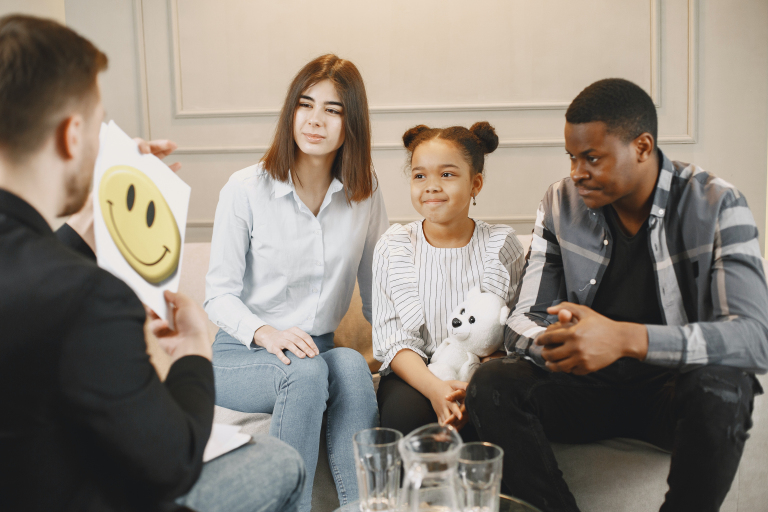 Child sitting with a parent at home before an online child counselling session