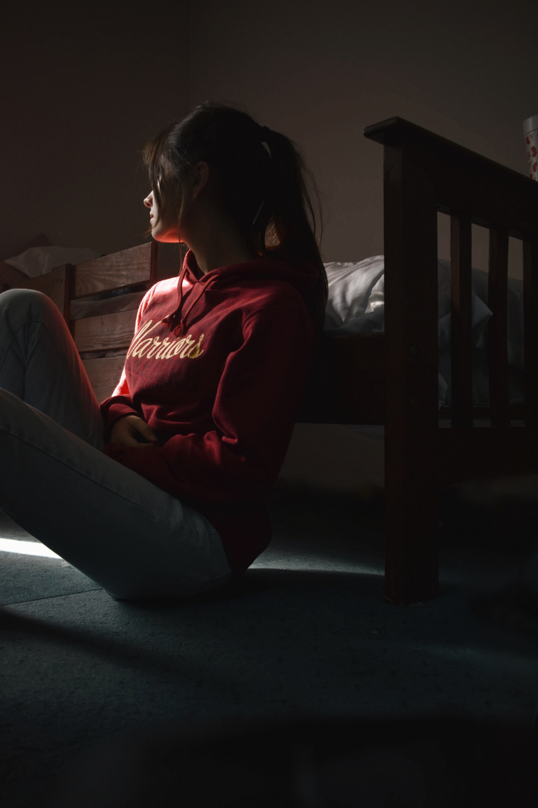 Woman looking out of a window at home before an online mood disorder counselling session