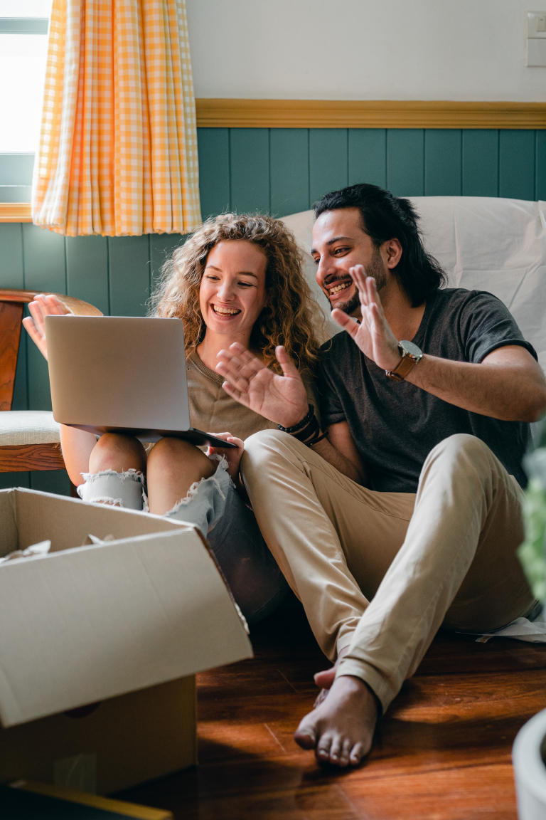 Couple sitting together on a sofa during an online couples counselling session